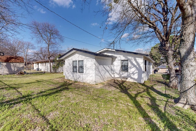 rear view of property featuring a yard and fence