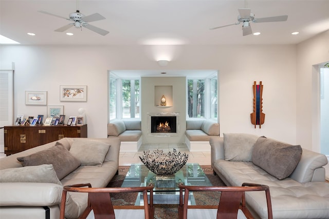 tiled living area with a warm lit fireplace, a ceiling fan, and recessed lighting