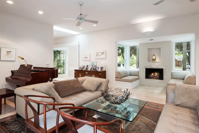 living room with a ceiling fan, recessed lighting, and a warm lit fireplace