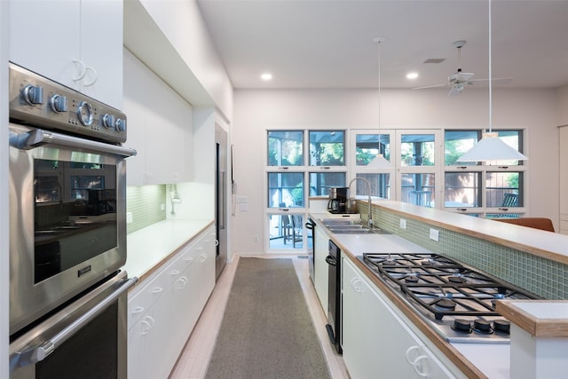 kitchen featuring stainless steel appliances, a sink, and white cabinetry