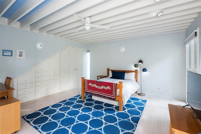 bedroom with beamed ceiling, wood finished floors, a ceiling fan, and baseboards