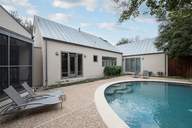 rear view of property with a standing seam roof, metal roof, and a patio