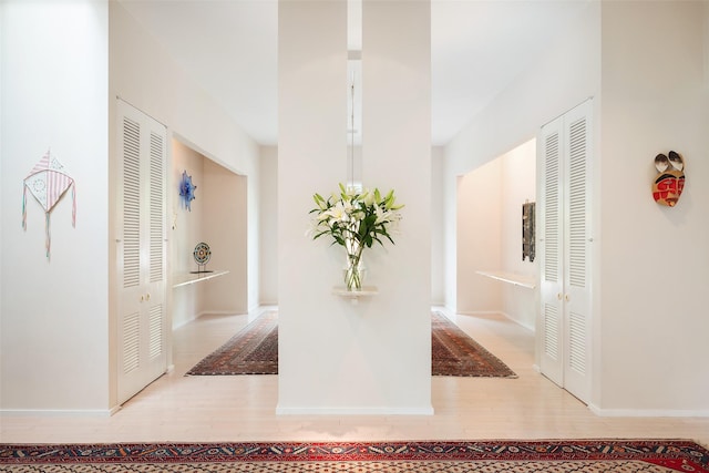 corridor featuring baseboards and wood finished floors