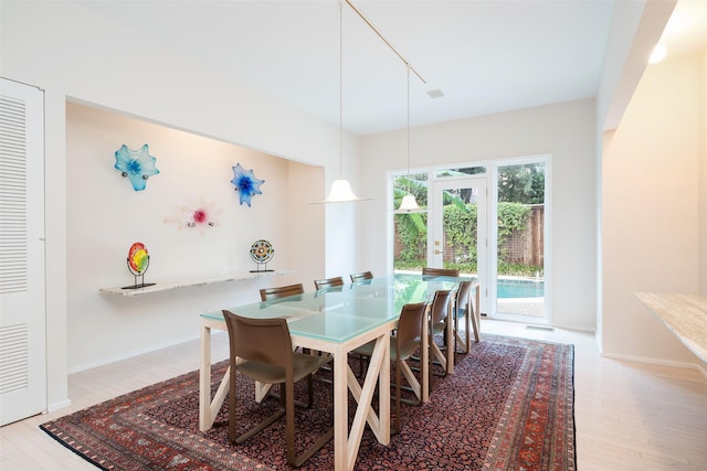 dining space with french doors, wood finished floors, and baseboards