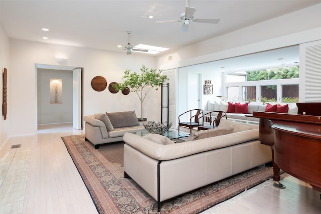 living room featuring recessed lighting, a skylight, visible vents, a ceiling fan, and light wood-type flooring