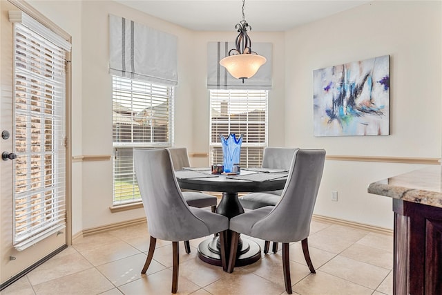 dining space featuring light tile patterned floors and baseboards