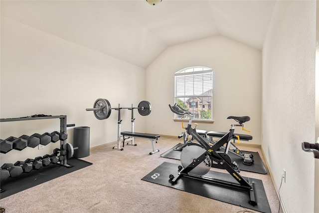 exercise room featuring carpet flooring, vaulted ceiling, and baseboards