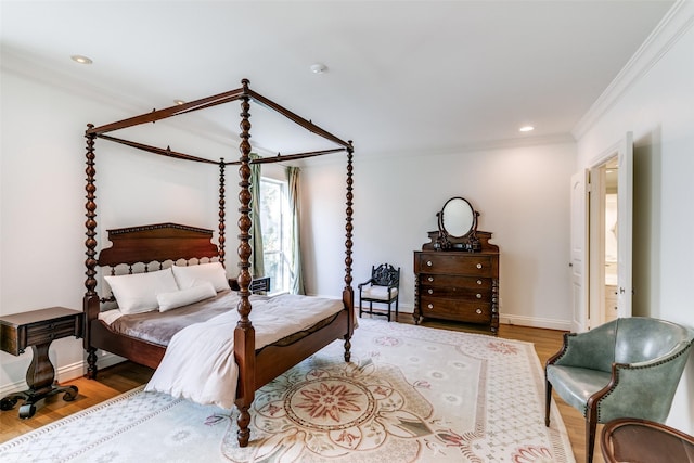 bedroom with crown molding, baseboards, wood finished floors, and recessed lighting