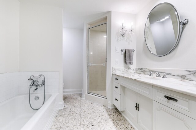 full bathroom with toilet, vanity, a shower stall, baseboards, and a bath