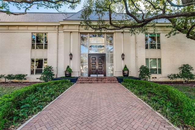 doorway to property with brick siding