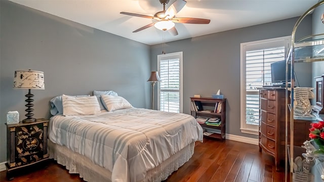 bedroom with a ceiling fan, baseboards, and dark wood-type flooring