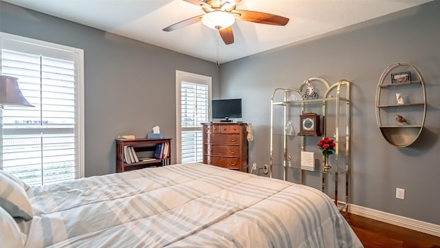 bedroom featuring ceiling fan, baseboards, and wood finished floors