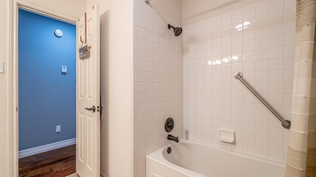 bathroom with shower / bathtub combination with curtain, baseboards, and wood finished floors