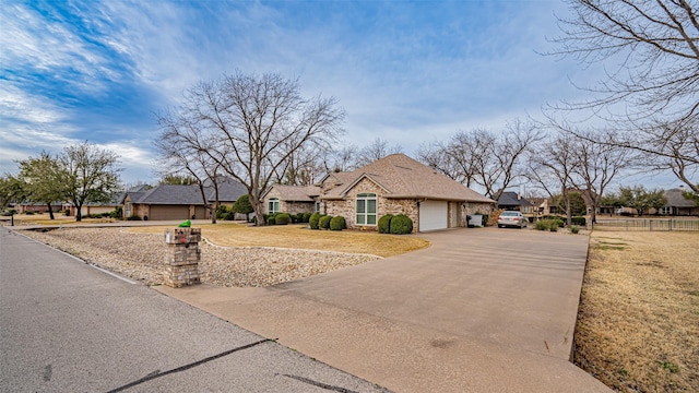 view of front of home with brick siding, fence, a garage, driveway, and a front lawn