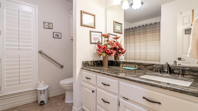 full bath with toilet, vanity, baseboards, and tile patterned floors