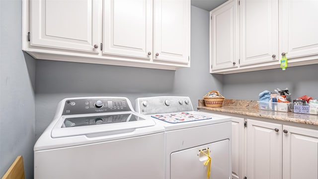 clothes washing area featuring independent washer and dryer and cabinet space