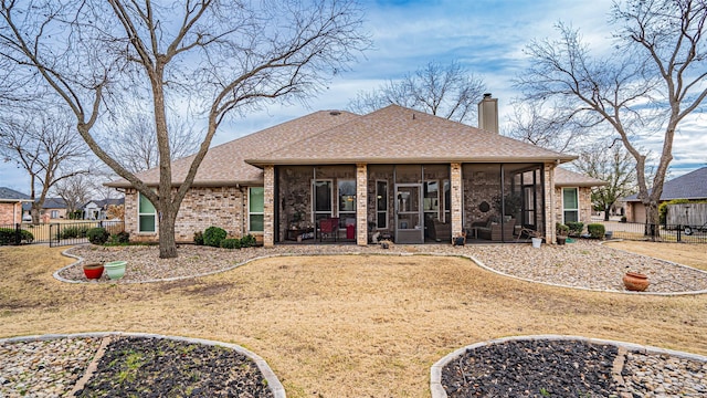 exterior space featuring brick siding, a chimney, a shingled roof, a sunroom, and fence