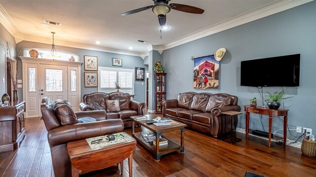 living room with a ceiling fan, visible vents, dark wood-type flooring, and ornamental molding