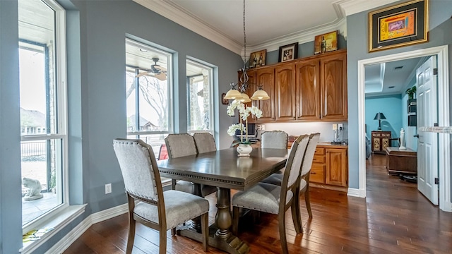 dining room with dark wood-style floors, a healthy amount of sunlight, baseboards, and crown molding