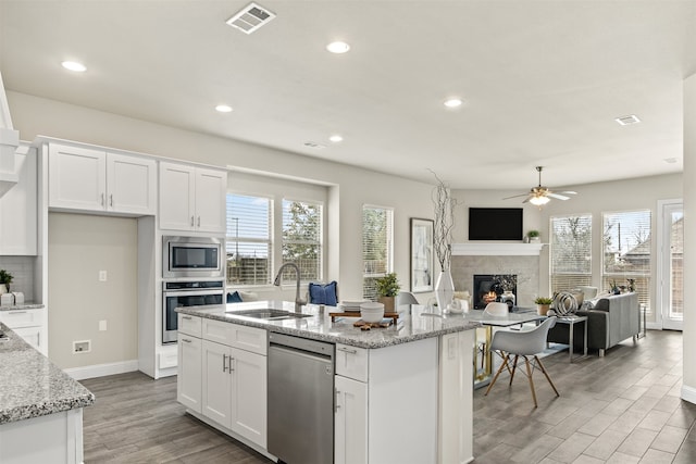 kitchen featuring a sink, visible vents, white cabinetry, appliances with stainless steel finishes, and light wood-type flooring