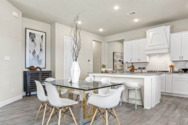 dining area with light wood-type flooring, visible vents, baseboards, and recessed lighting