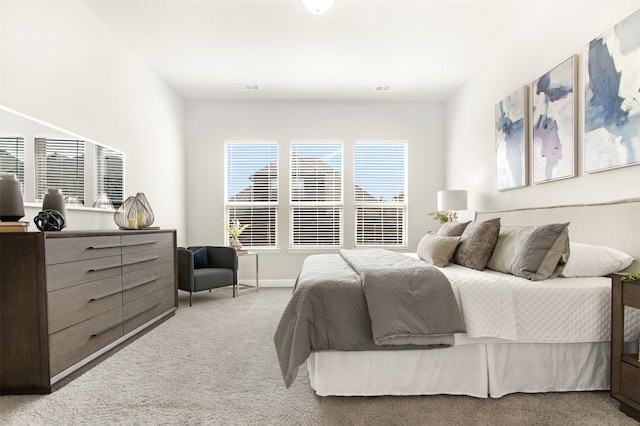 bedroom featuring light carpet, visible vents, and baseboards