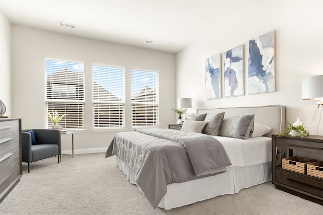 bedroom with visible vents, light carpet, and baseboards