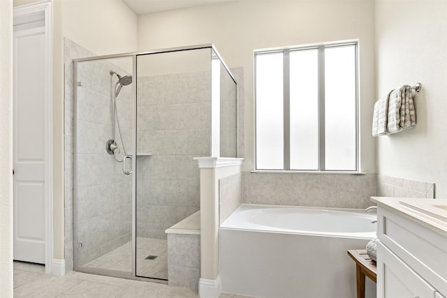 bathroom with a garden tub, a shower stall, tile patterned flooring, and vanity