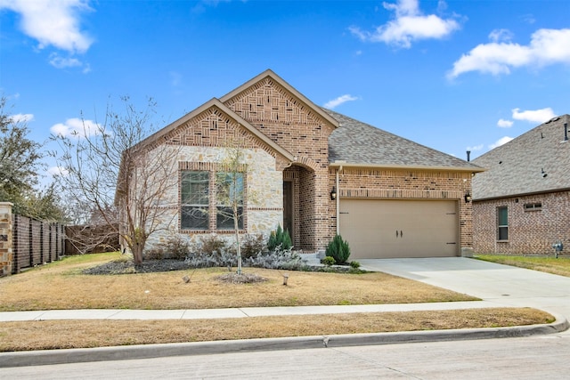 view of front facade with brick siding, a shingled roof, concrete driveway, an attached garage, and fence