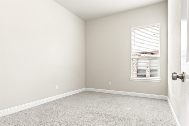 empty room featuring light carpet and baseboards