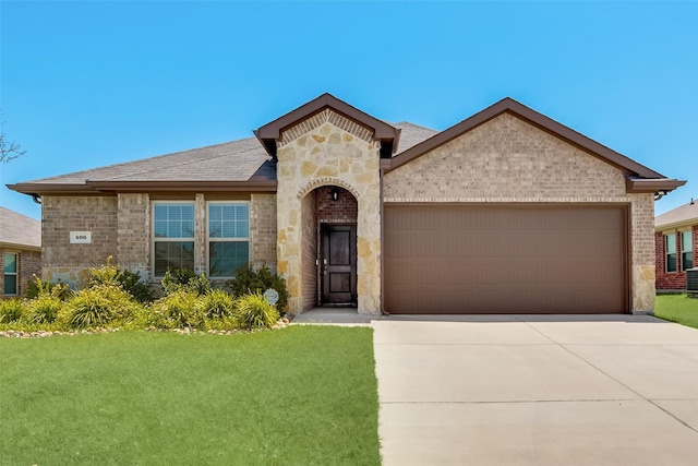 view of front of house with a garage, brick siding, concrete driveway, stone siding, and a front yard