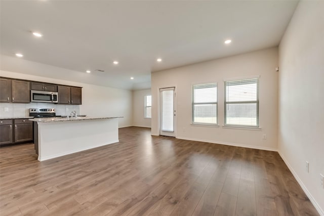 kitchen with stainless steel appliances, recessed lighting, decorative backsplash, and wood finished floors