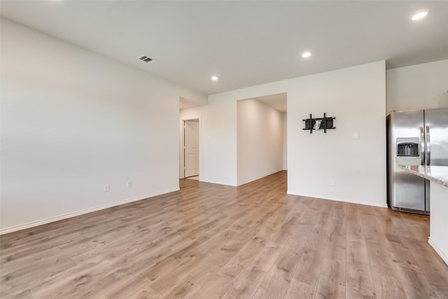 unfurnished living room with light wood-type flooring, baseboards, visible vents, and recessed lighting