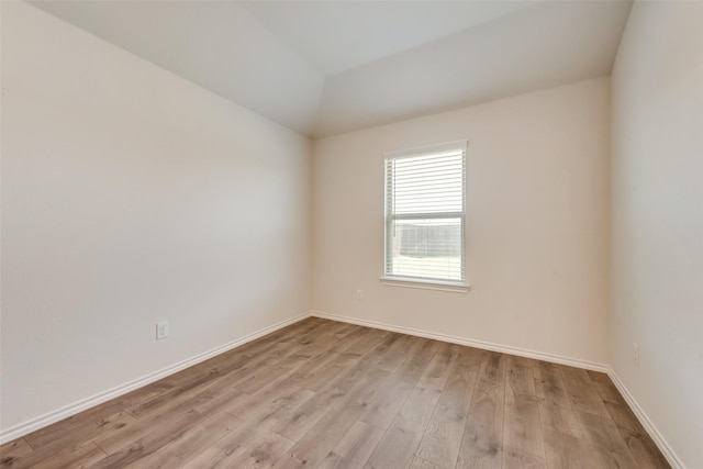 spare room featuring light wood-type flooring and baseboards