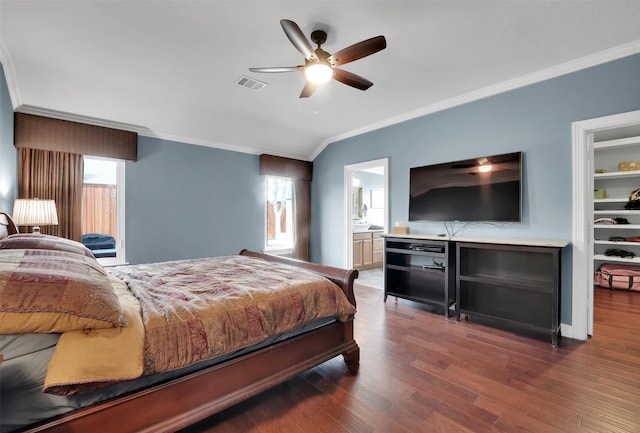 bedroom featuring multiple windows, visible vents, wood finished floors, and ornamental molding