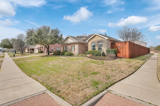 view of front facade with brick siding and a front lawn