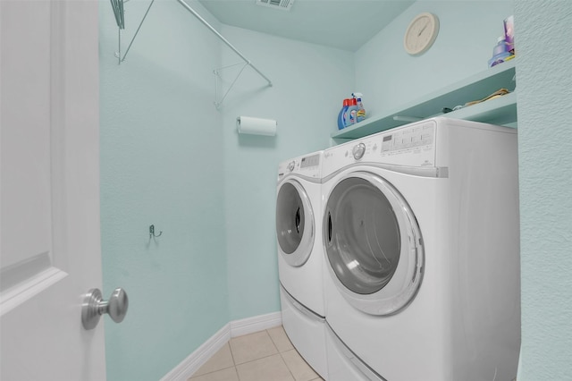 washroom with light tile patterned floors, laundry area, visible vents, and washer and dryer