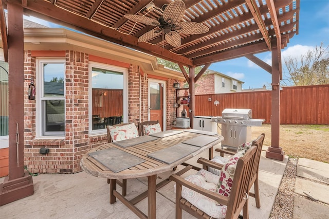 view of patio with ceiling fan, grilling area, fence, a pergola, and outdoor dining space