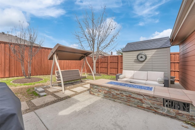 view of patio / terrace featuring an outbuilding, outdoor lounge area, a fenced backyard, and a shed