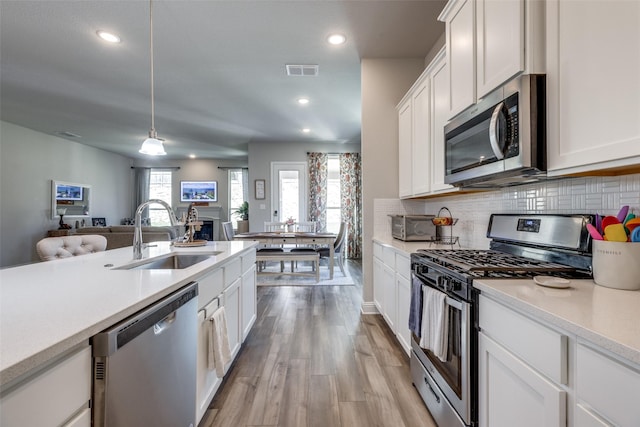 kitchen with visible vents, appliances with stainless steel finishes, light countertops, and a sink