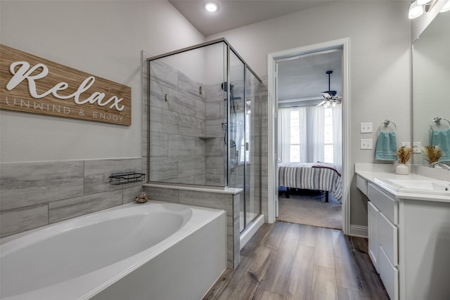 bathroom with a stall shower, wood finished floors, ensuite bathroom, a garden tub, and vanity