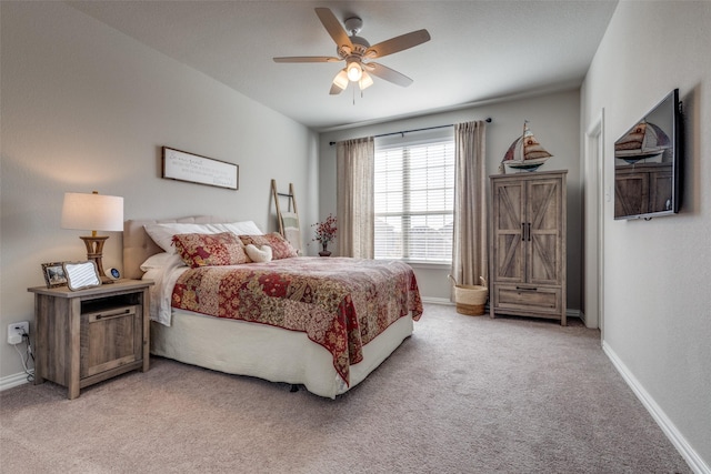 bedroom with a ceiling fan, light carpet, and baseboards