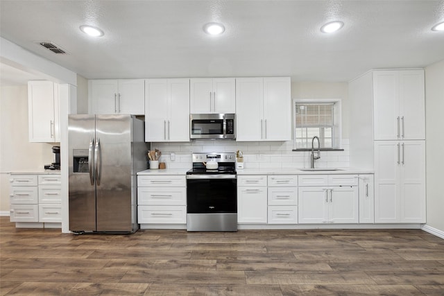 kitchen featuring dark wood-style floors, visible vents, stainless steel appliances, and a sink