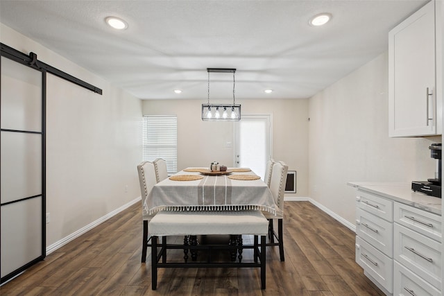 dining area with recessed lighting, dark wood finished floors, baseboards, and a barn door