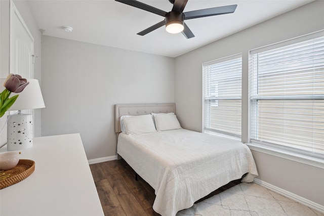 bedroom with ceiling fan, baseboards, and wood finished floors