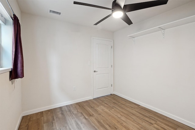 spare room featuring baseboards, visible vents, ceiling fan, and light wood finished floors