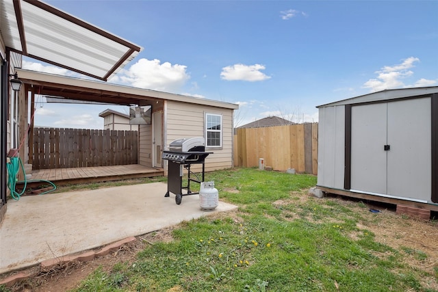 view of yard with an outbuilding, a fenced backyard, a patio, and a shed