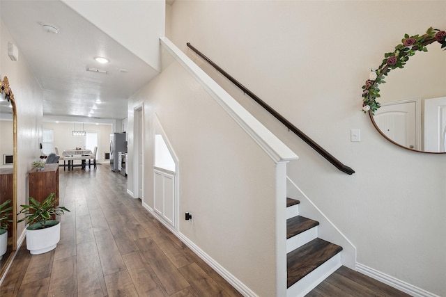 hallway with stairway, baseboards, and wood finished floors