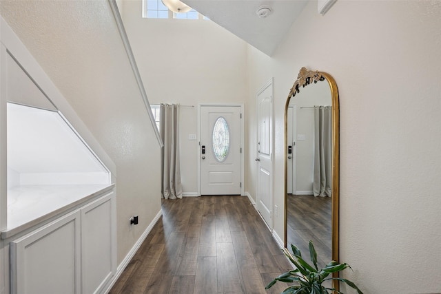 entryway featuring high vaulted ceiling, dark wood finished floors, and baseboards