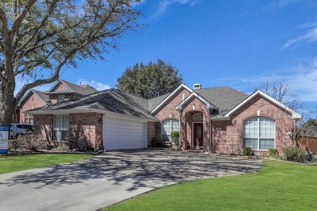 single story home with a garage, brick siding, driveway, and a front lawn